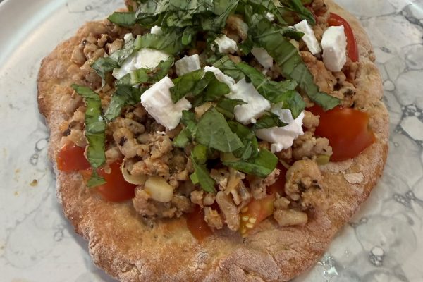 Homemade naan bread topped with Dewfresh chicken mince, feta cheese, cherry tomatoes and fresh basil